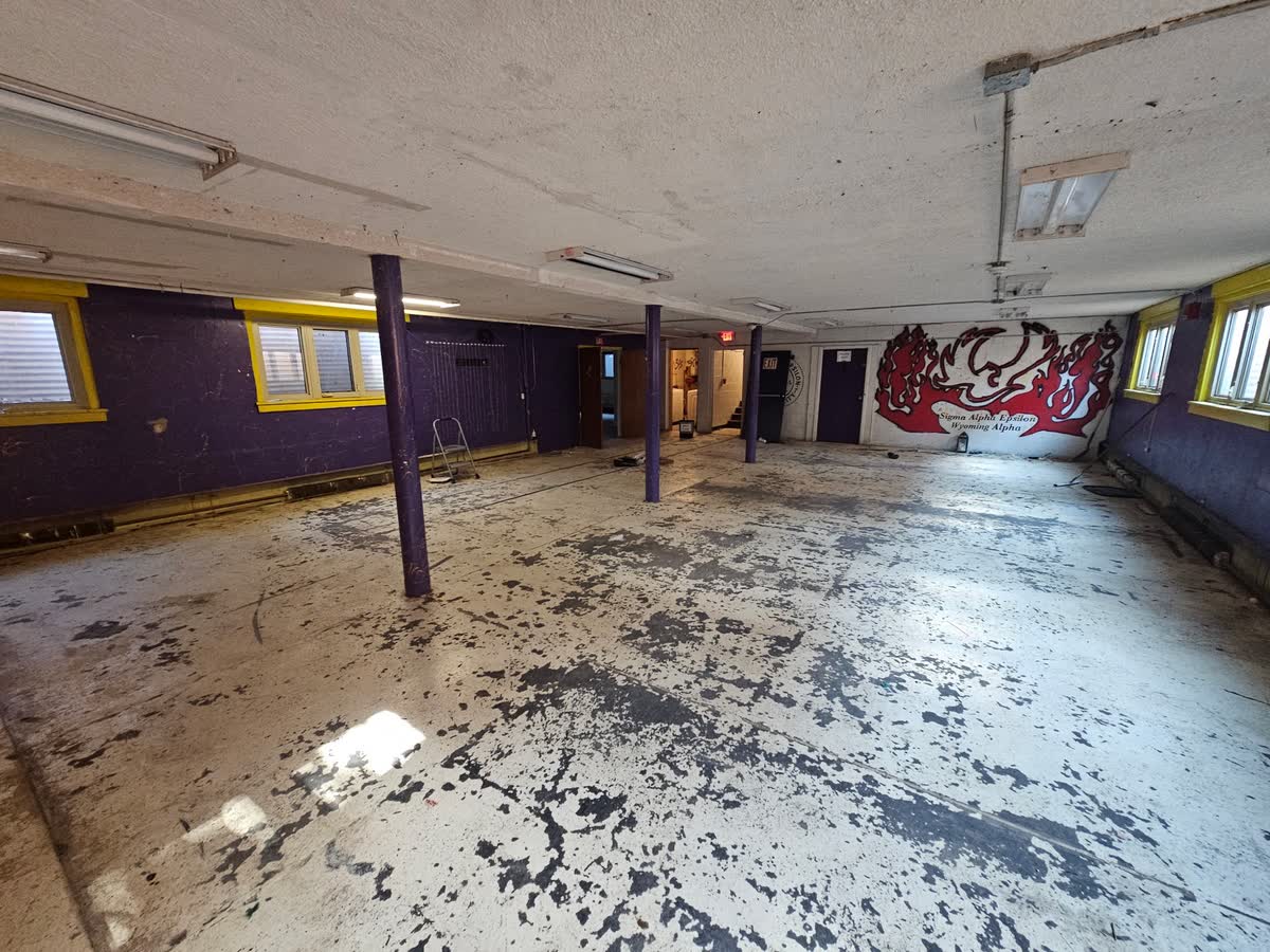 Basement main hall cleared, SAE mural on wall, July 17 2026