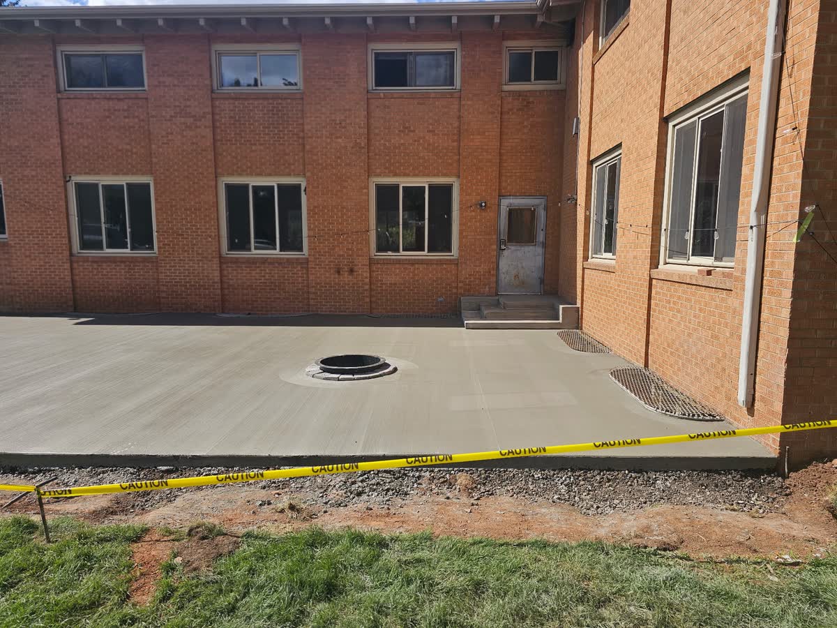 Fresh concrete patio poured at rear courtyard, July 17 2026