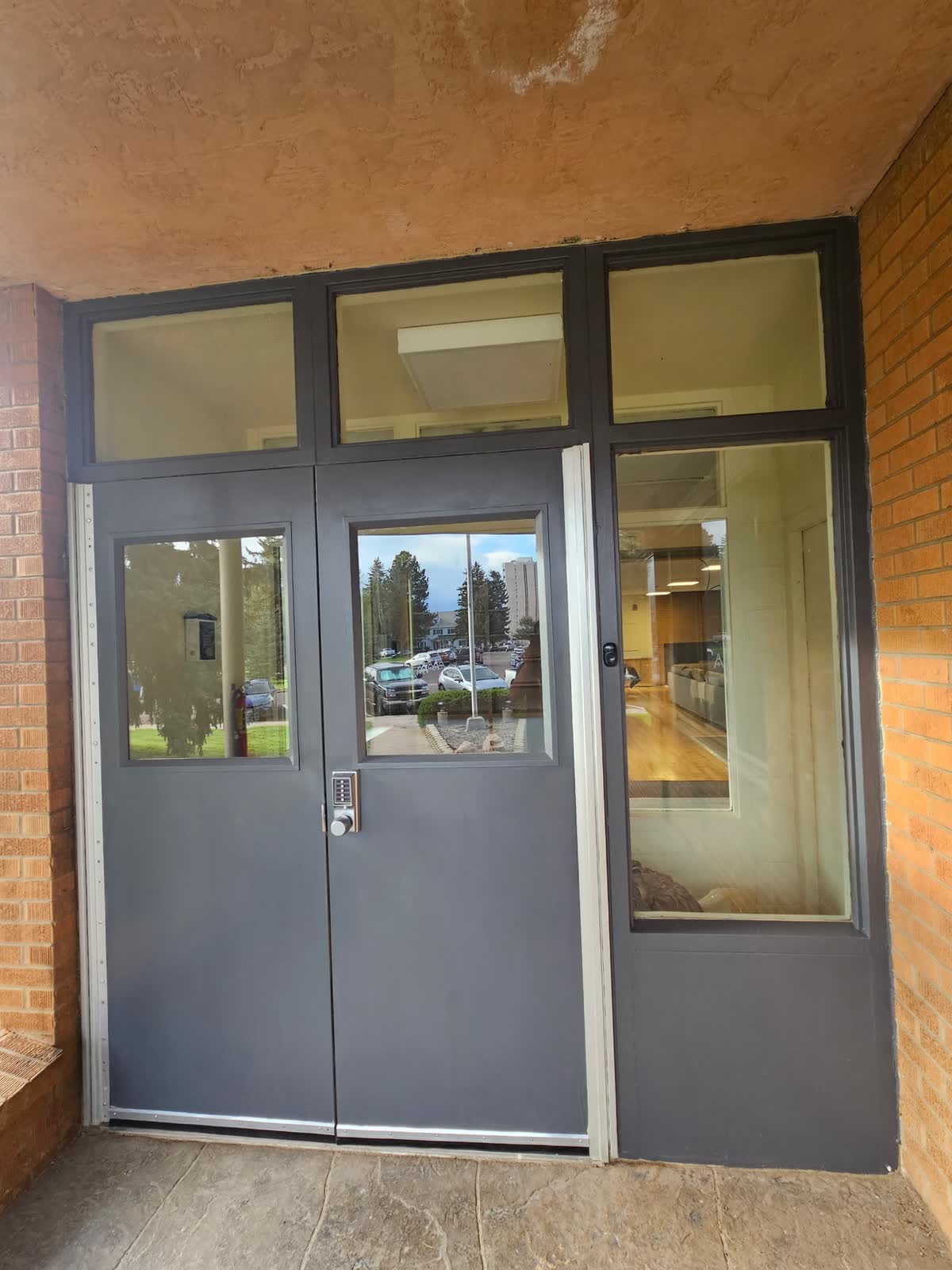 New dark steel entry doors installed at front entrance, August 21 2026