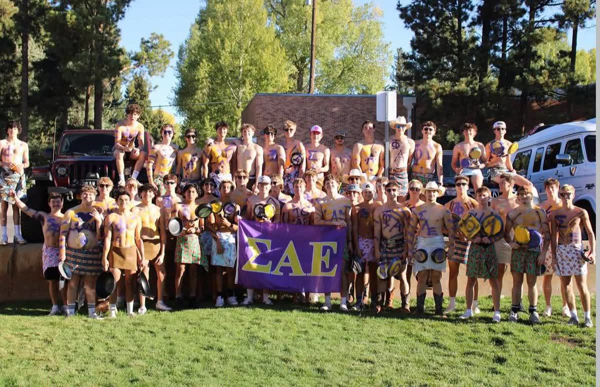 Wyoming Alpha brothers with the SAE flag, body paint and pans at the Fall 2026 parade
